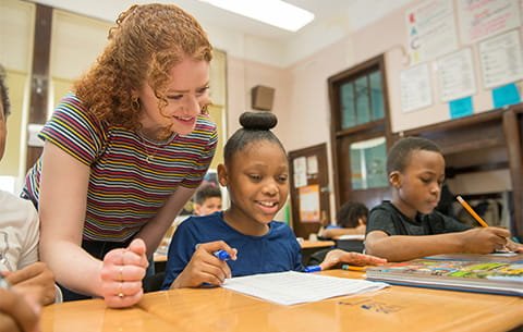 A teacher works with young students